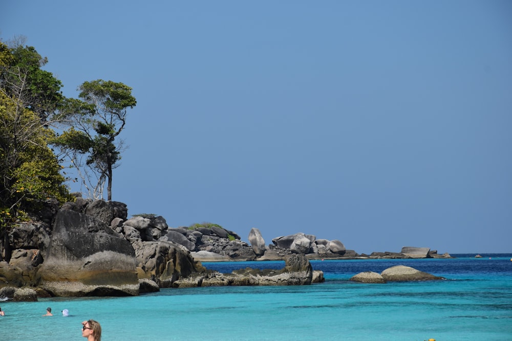 a woman standing on a beach next to the ocean