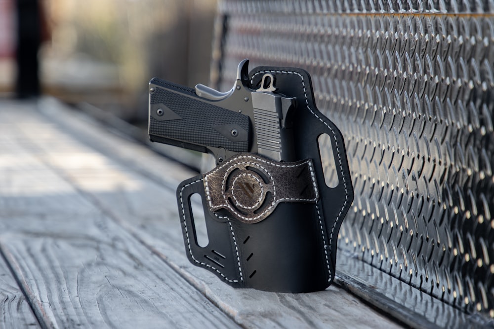 a black leather holster on a wooden bench