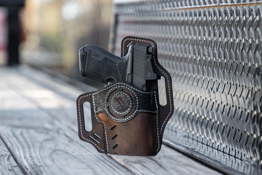 a leather holster with a gun on a bench