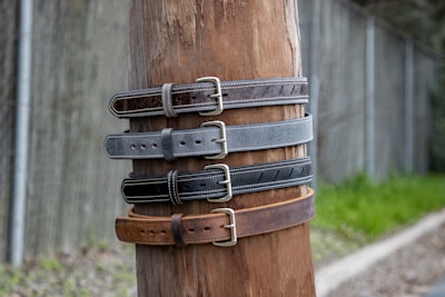 a wooden pole with a bunch of belts on it