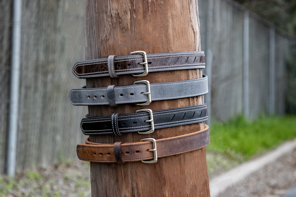 a wooden pole with a bunch of belts on it
