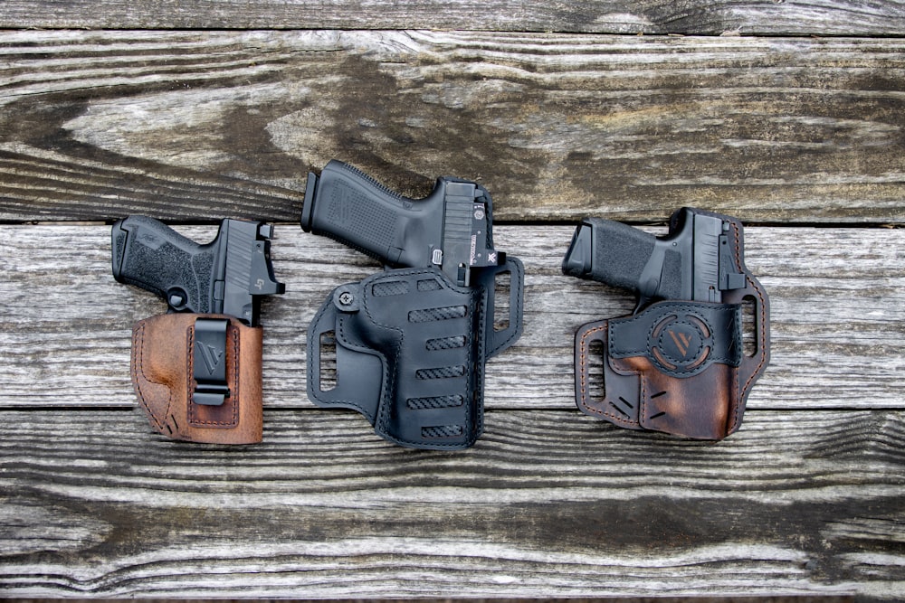 a couple of holsters sitting on top of a wooden table