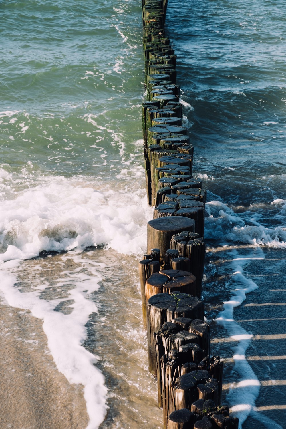 a long wooden pier sitting on top of a sandy beach