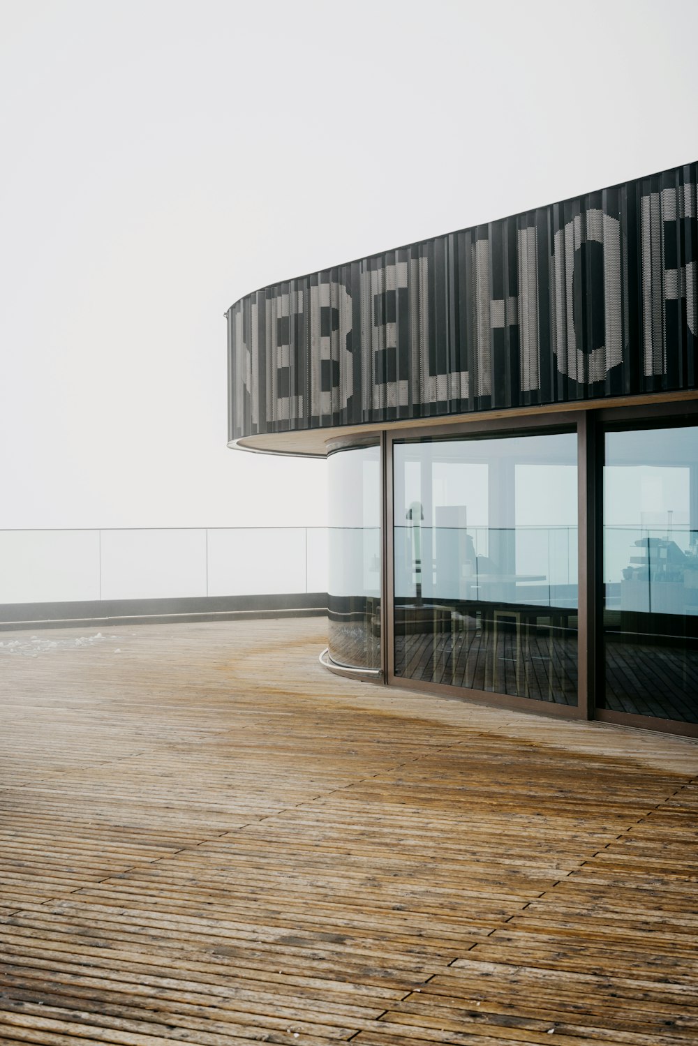 a wooden deck with a building with a sign on it