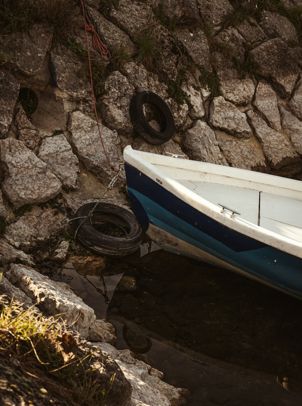 a blue and white boat sitting on top of a body of water