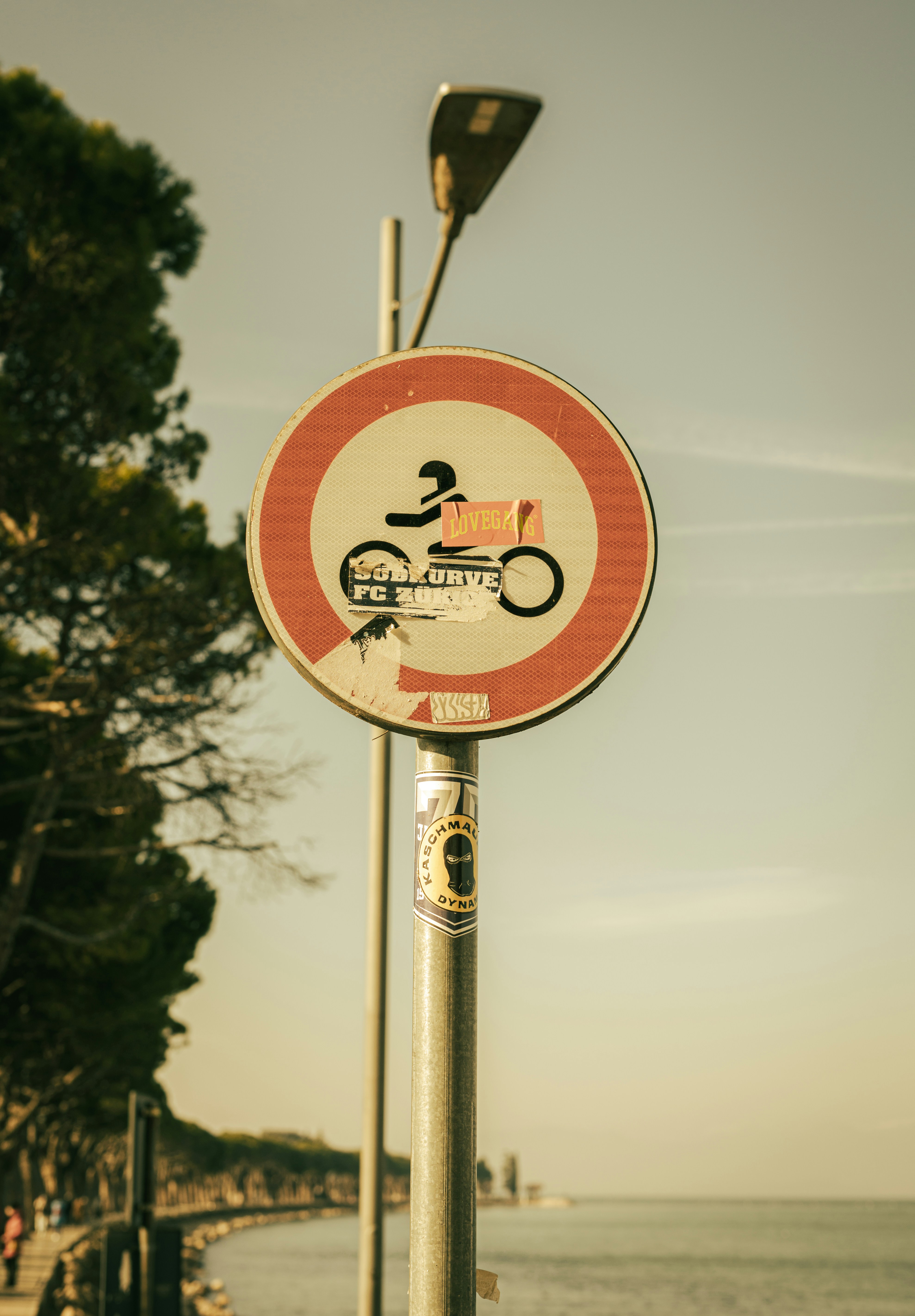 a red and white sign sitting on the side of a road