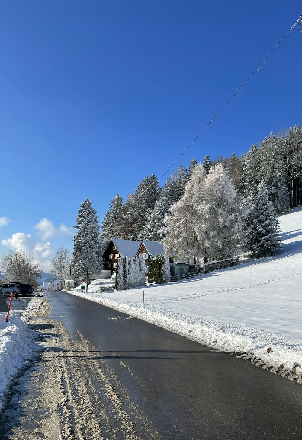 a snow covered road with a house in the background