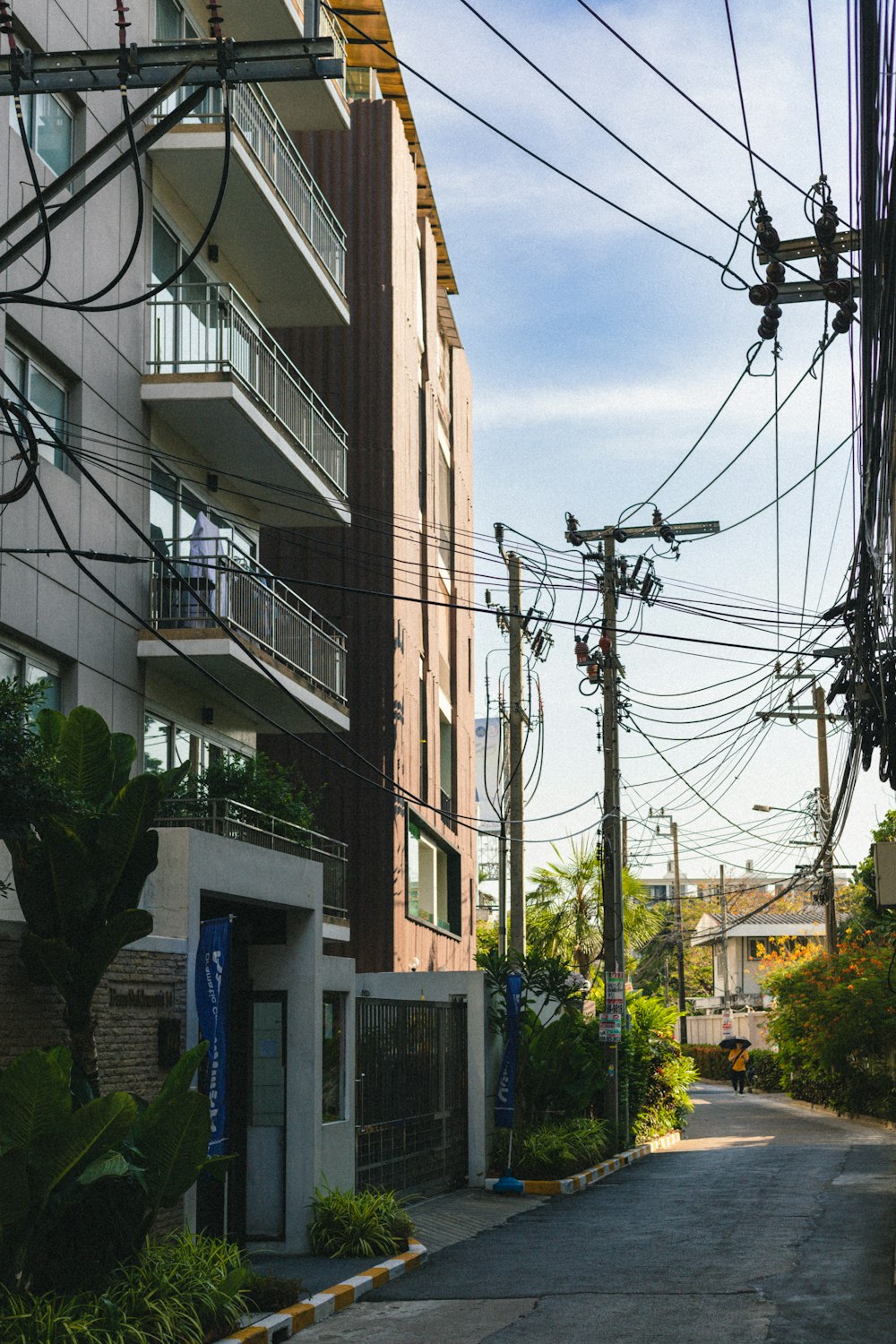 Una calle vacía con un edificio y líneas eléctricas al fondo