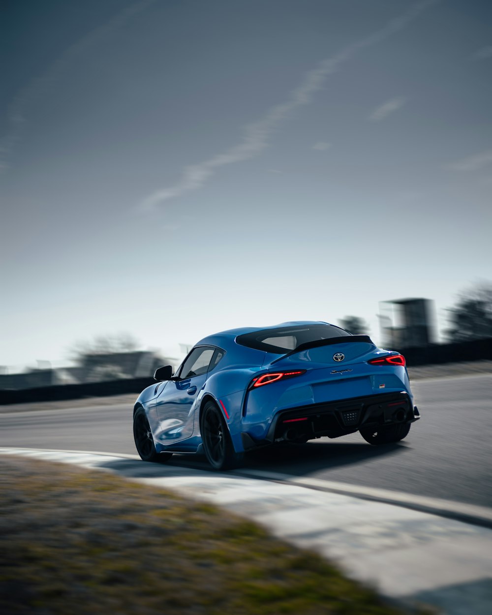 a blue sports car driving on a track