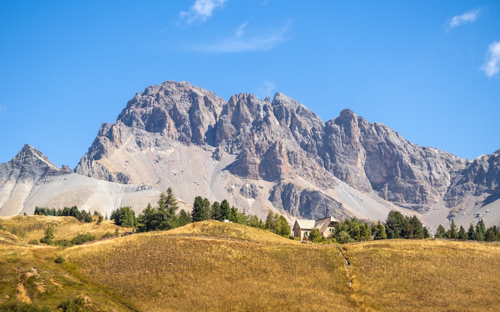 a mountain range with a house in the foreground