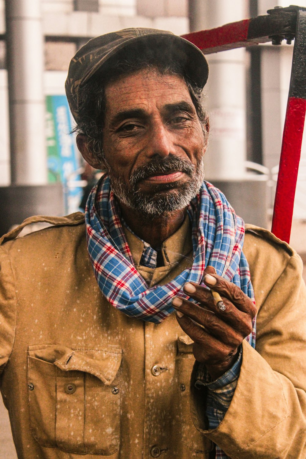 a man with a hat and scarf holding a pipe