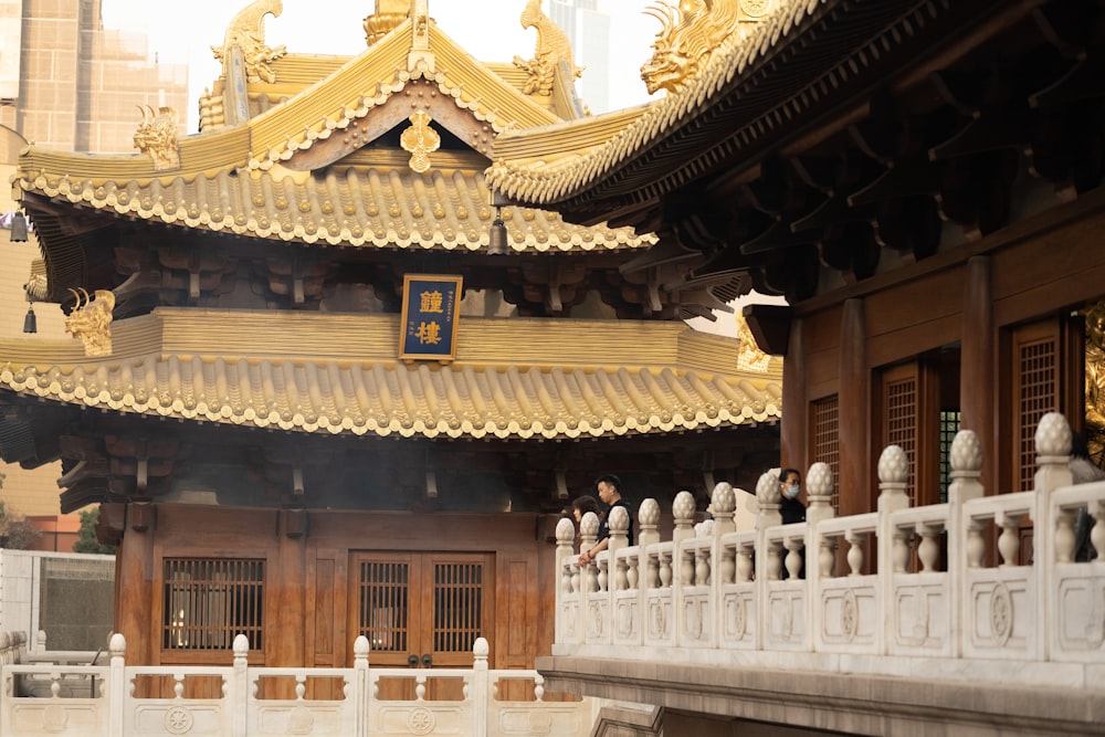 a building with a golden roof and a white fence