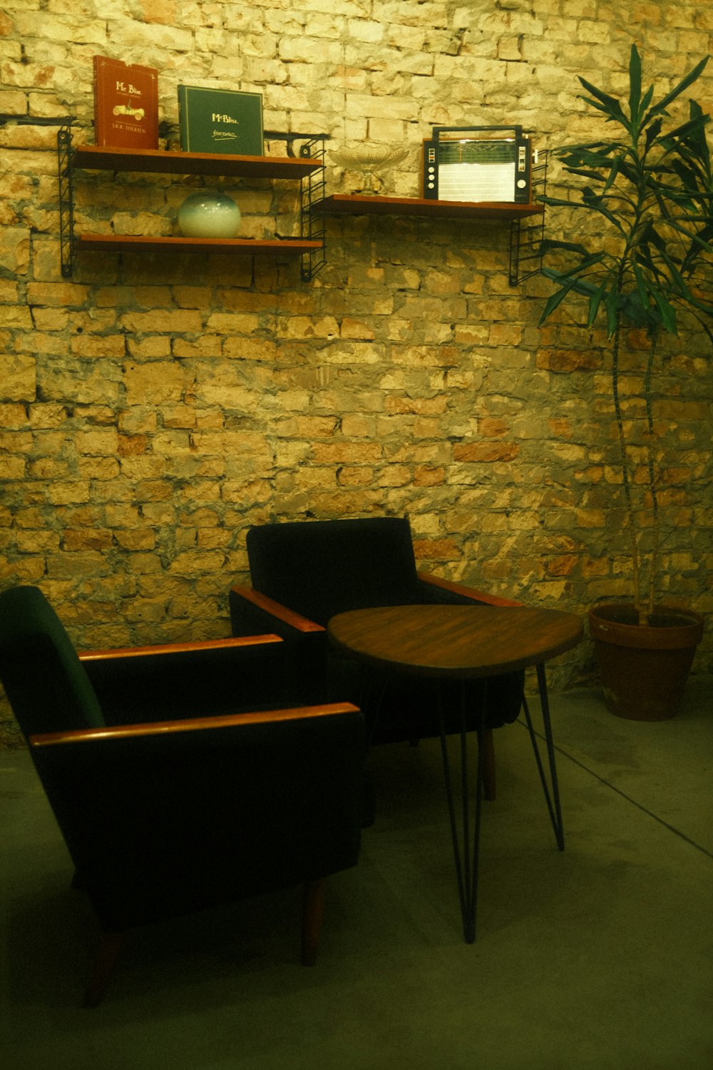 two chairs and a table in front of a brick wall