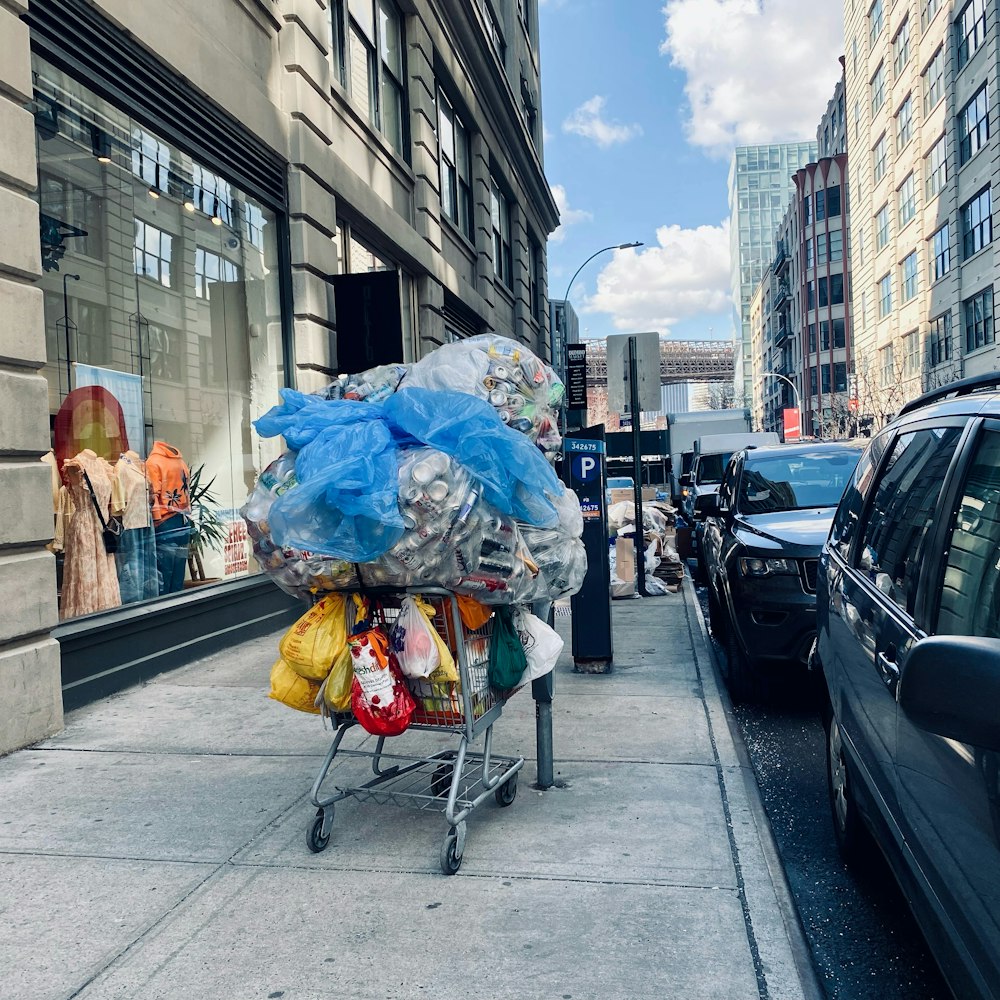 a shopping cart filled with plastic bags on a city street
