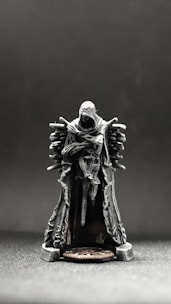 a small statue of a man sitting on top of a chair