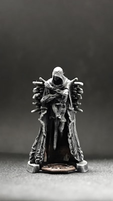 a small statue of a man sitting on top of a chair