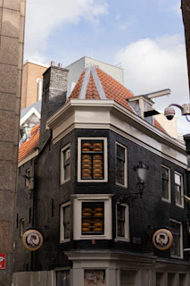 A vintage black-and-white photo of the original family cheese-making workshop with early equipment and smiling founders.