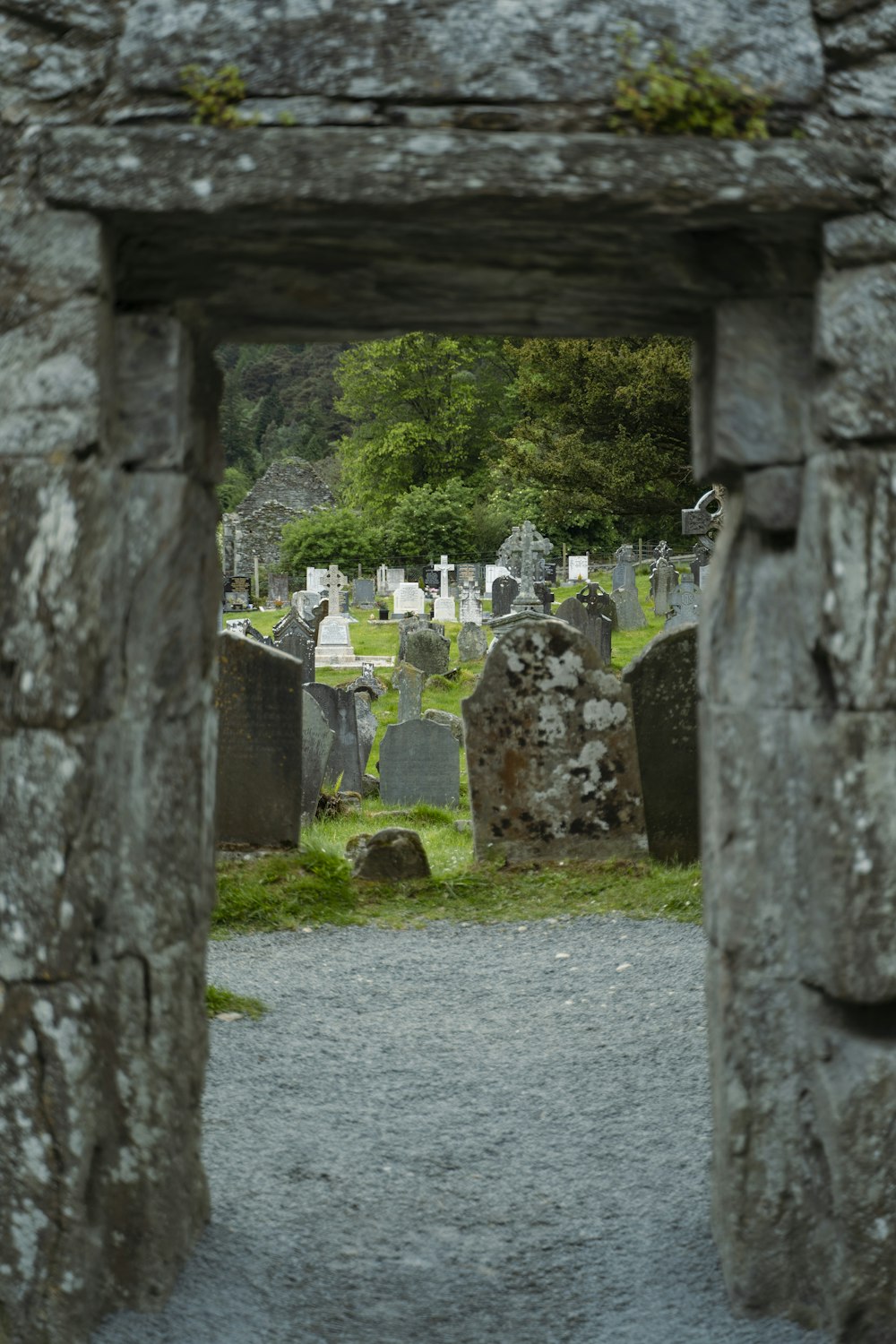 a cemetery with a stone archway leading into the cemetery