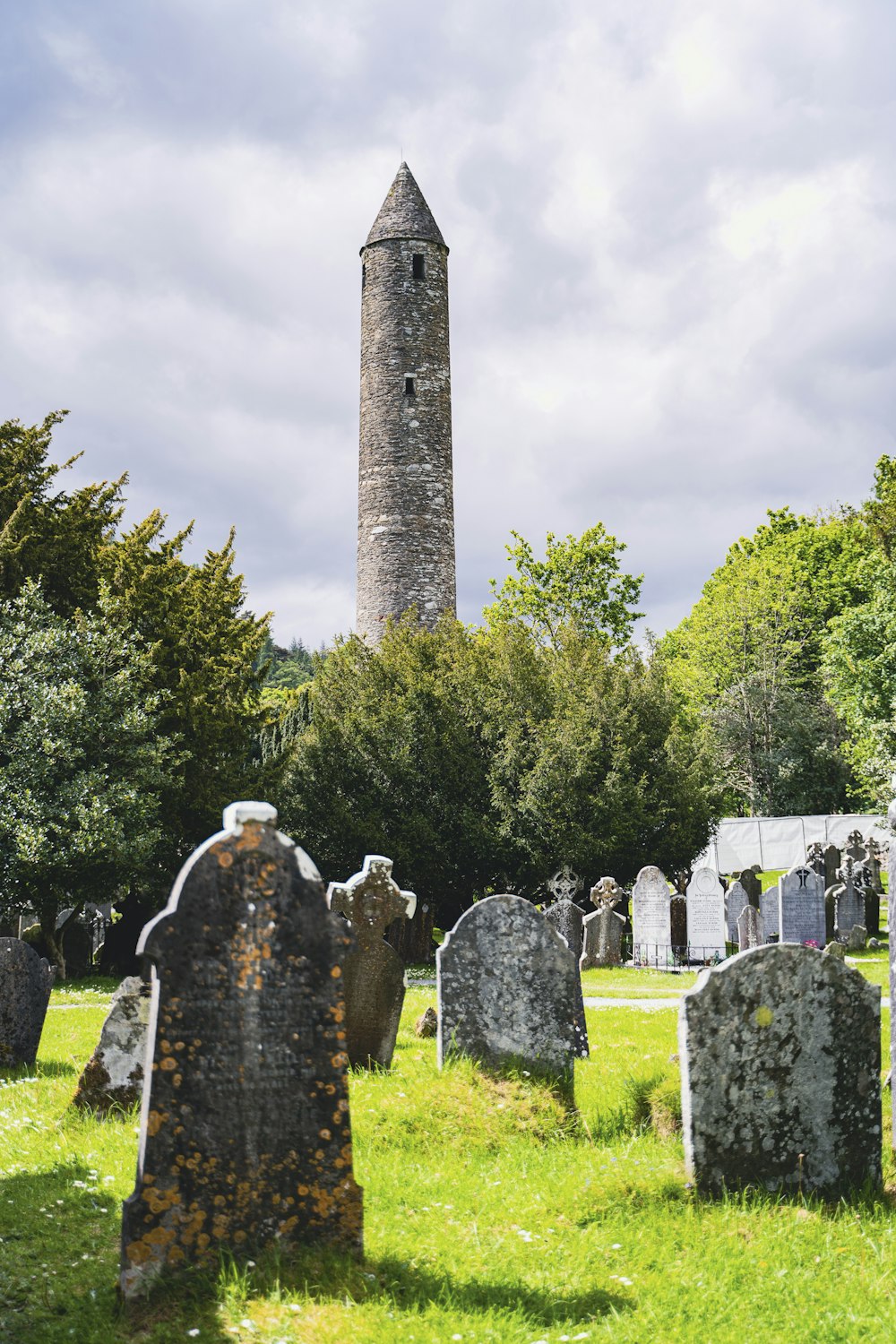 a cemetery with a tall tower in the background