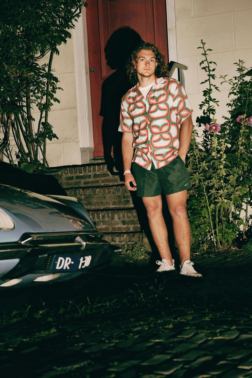 a young man standing in front of a house