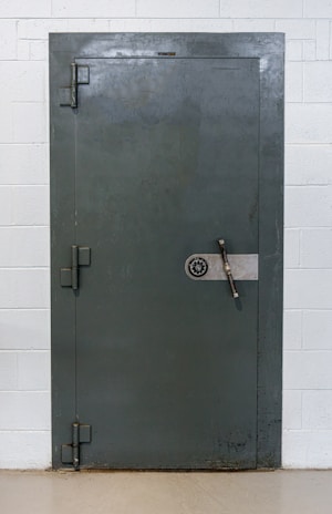 Expert unlocking a heavy safe door with precision in a secure office environment.