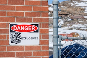 a danger sign is posted on a brick wall