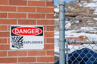 a danger sign is posted on a brick wall