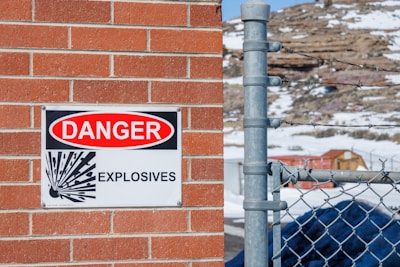 a danger sign is posted on a brick wall