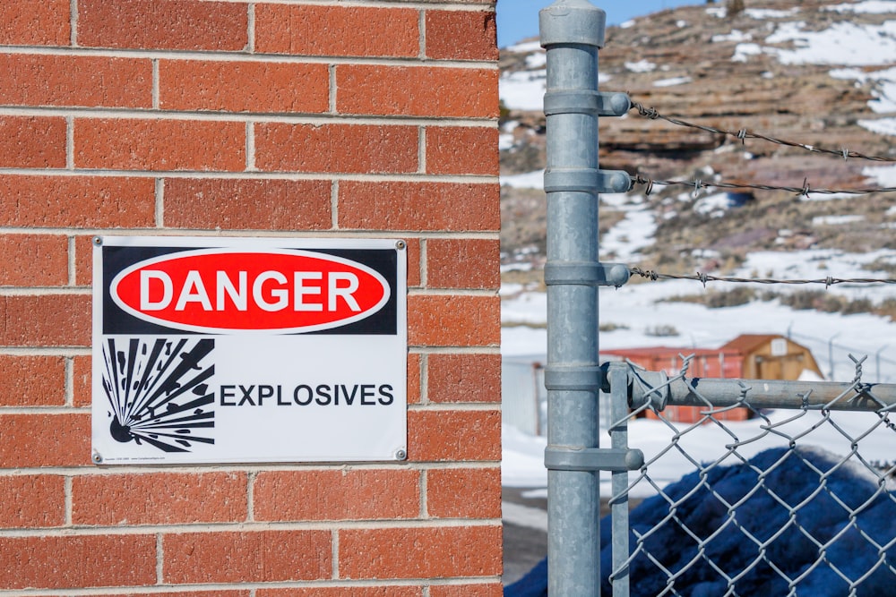 a danger sign is posted on a brick wall