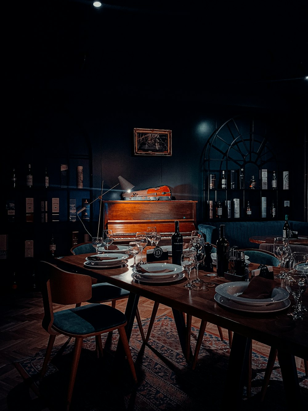 a dark room with a table and a piano