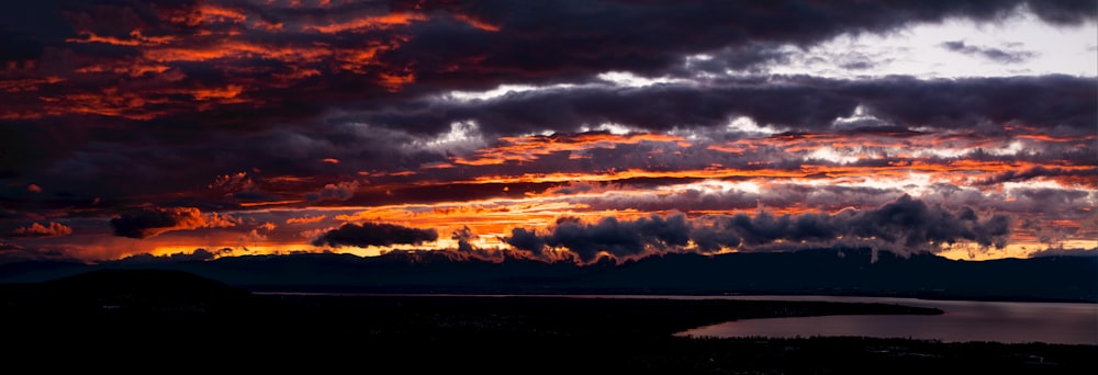 a beautiful sunset over a lake and mountains