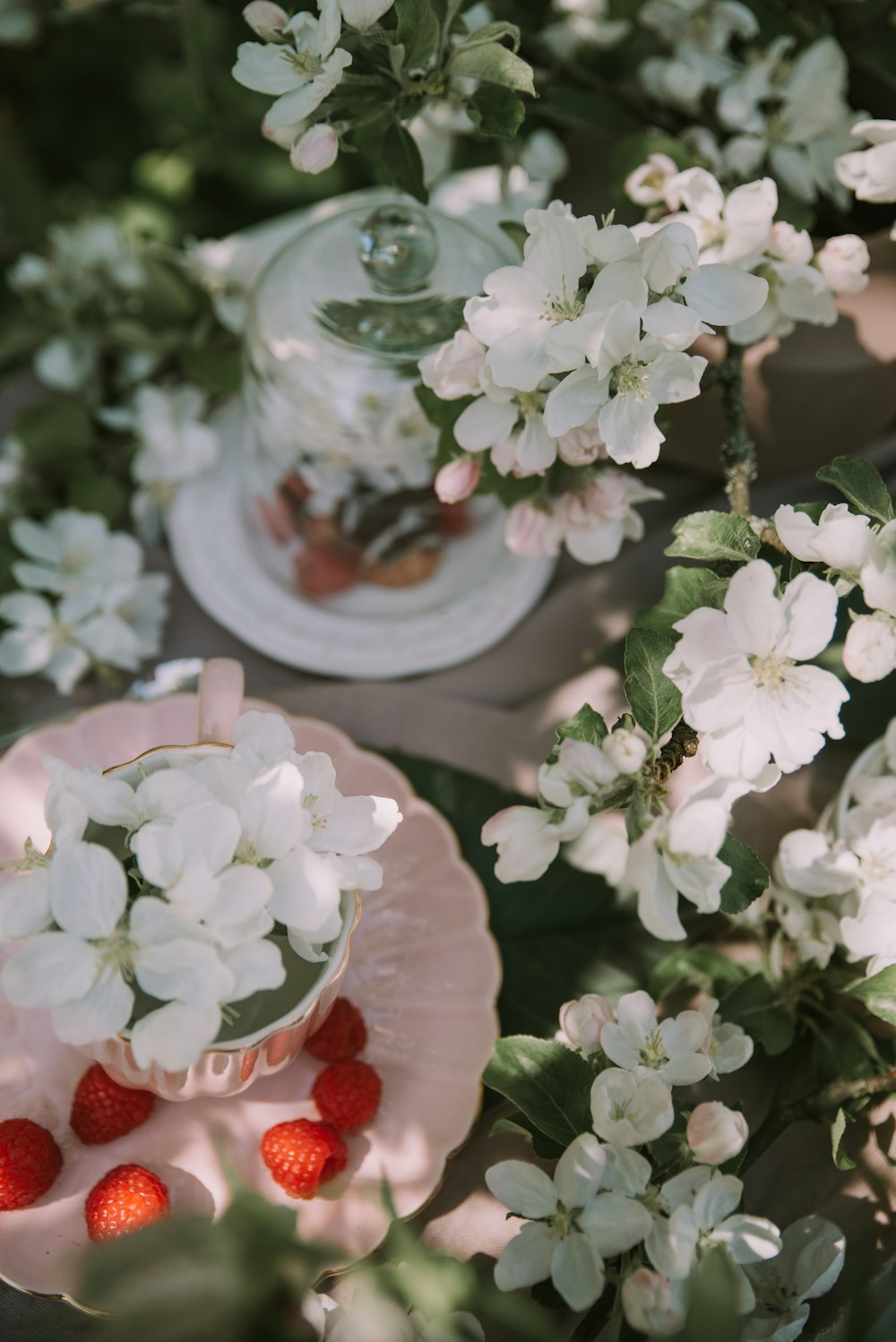 a plate with strawberries and flowers on a table