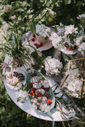 A private garden party featuring soft sage green tableware and ivory floral centerpieces.