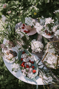 A private garden party featuring soft sage green tableware and ivory floral centerpieces.