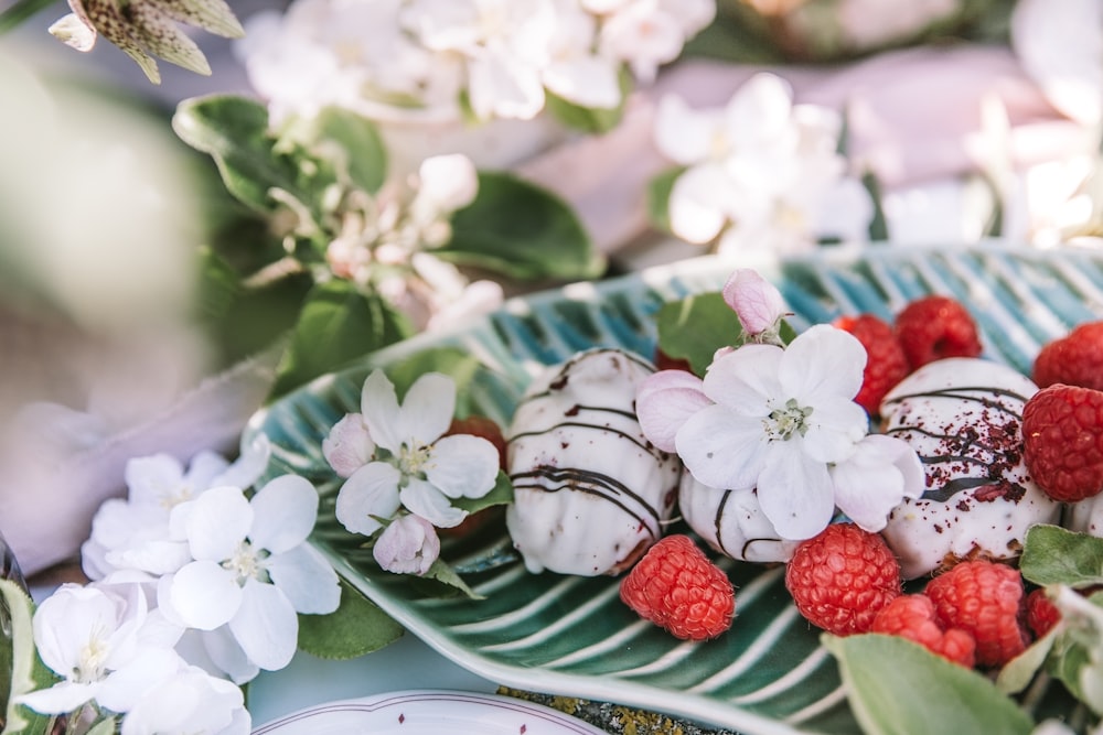 a plate of raspberries and chocolate covered strawberries