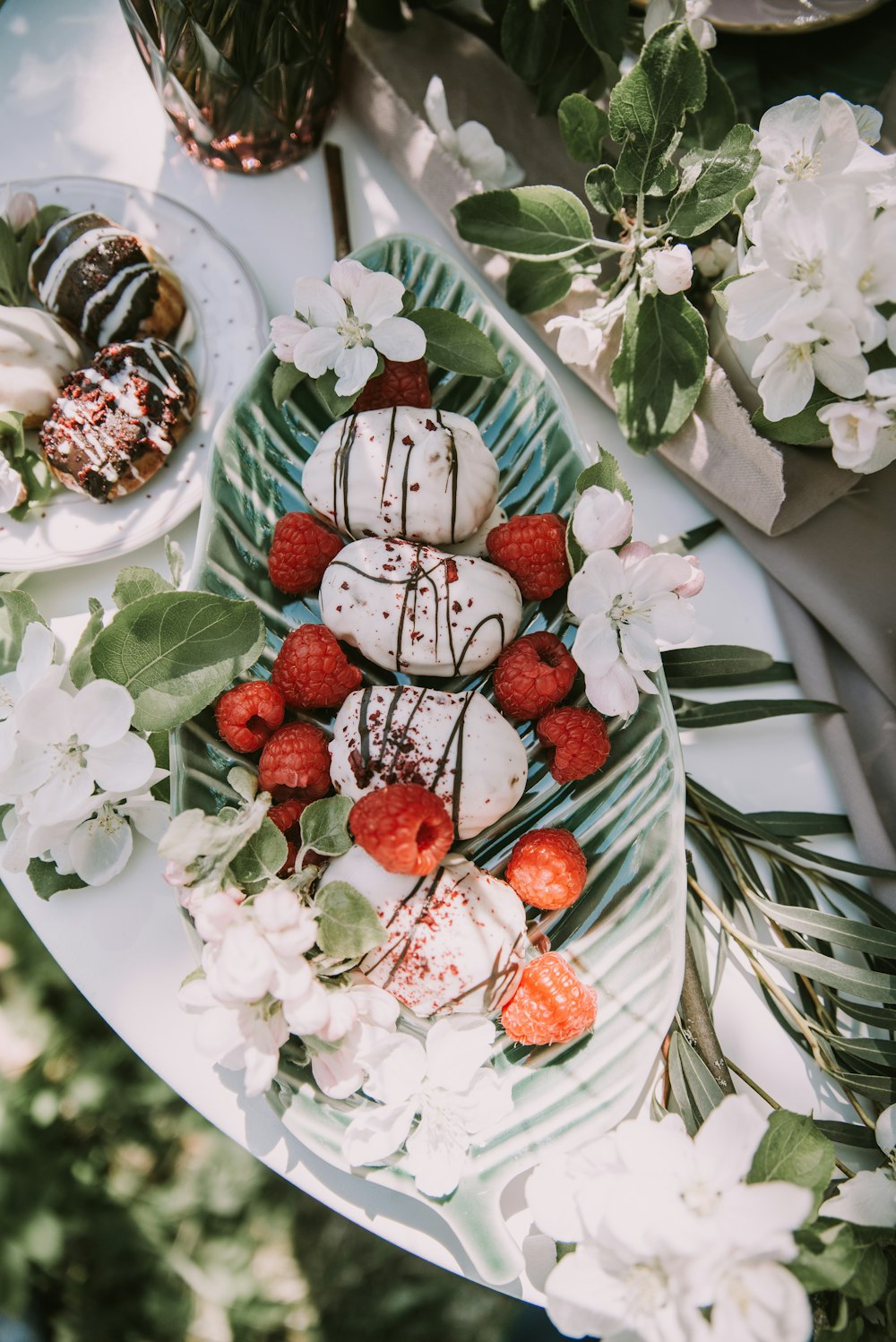 a platter of strawberries and other desserts on a table