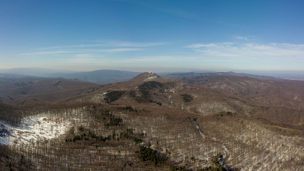 an aerial view of a mountain range with snow on the ground