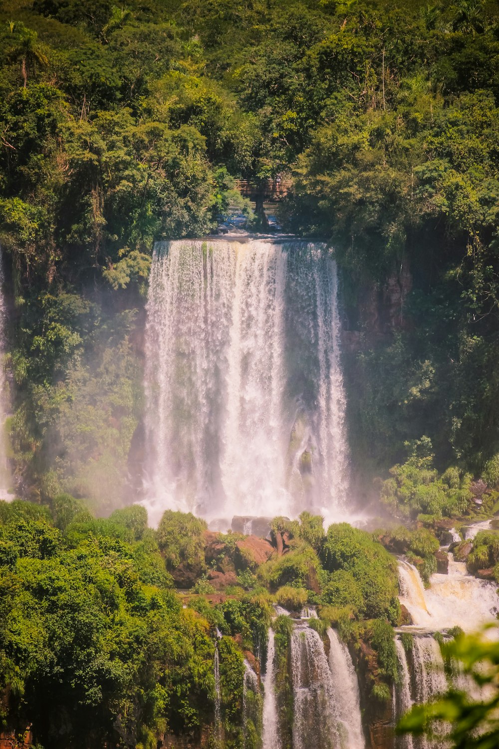 a large waterfall in the middle of a forest