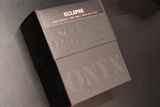 Close-up of the éclatvive logo embossed on a sleek black gift box, emphasizing brand identity.