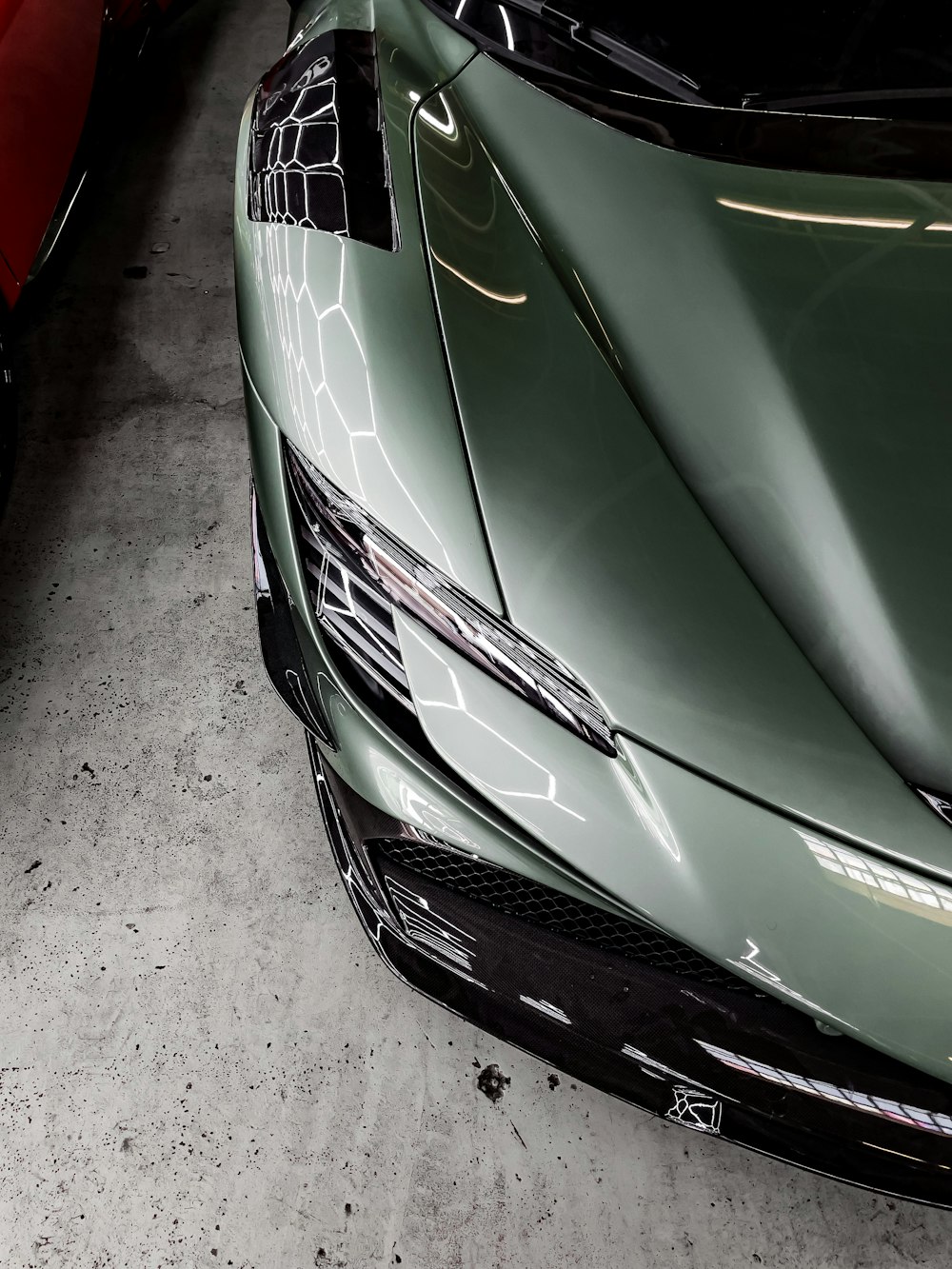 a green sports car parked in a garage