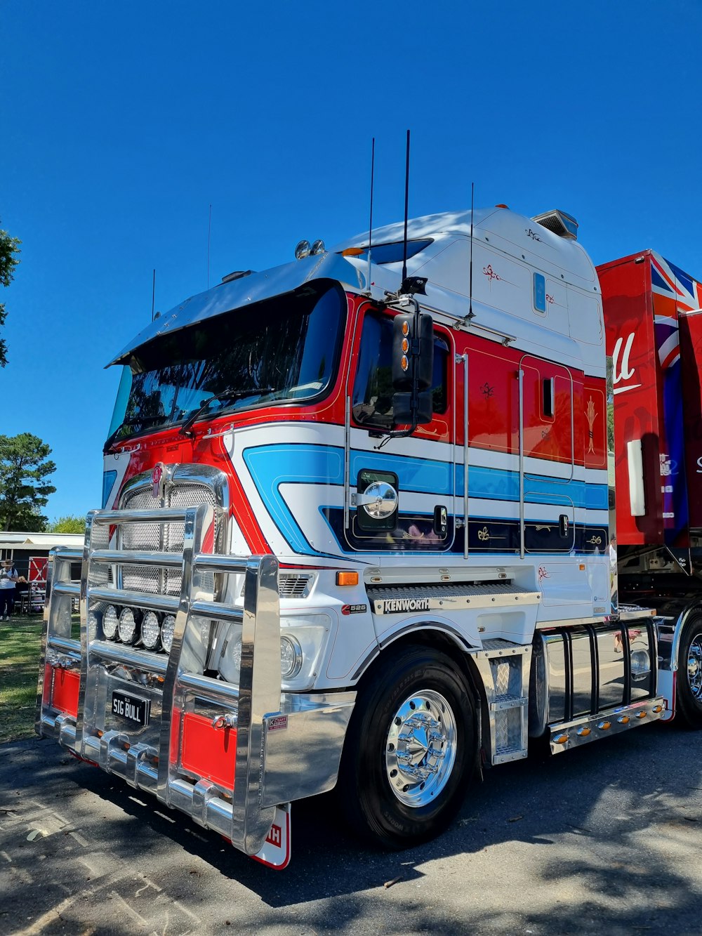 a semi truck with a red, white, and blue trailer