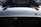 Close-up of a sleek car with the brand logo 'Ferrari' prominently displayed on the rear, showcasing a glossy black surface.