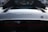 Close-up of a sleek car with the brand logo 'Ferrari' prominently displayed on the rear, showcasing a glossy black surface.