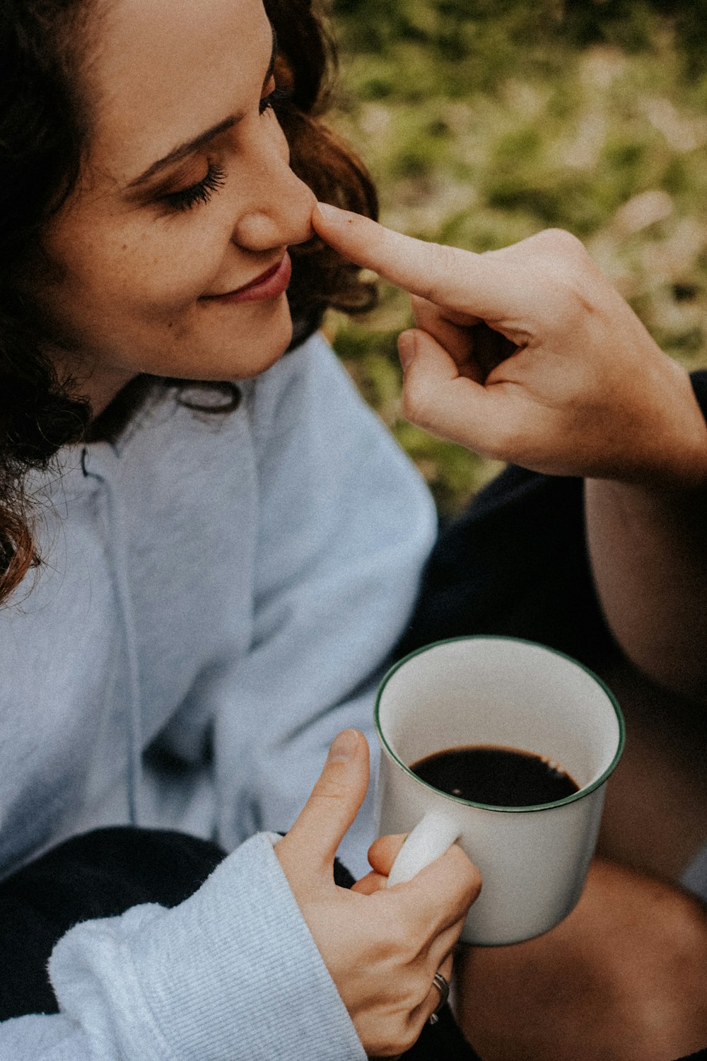 a woman holding a cup of coffee in her hand