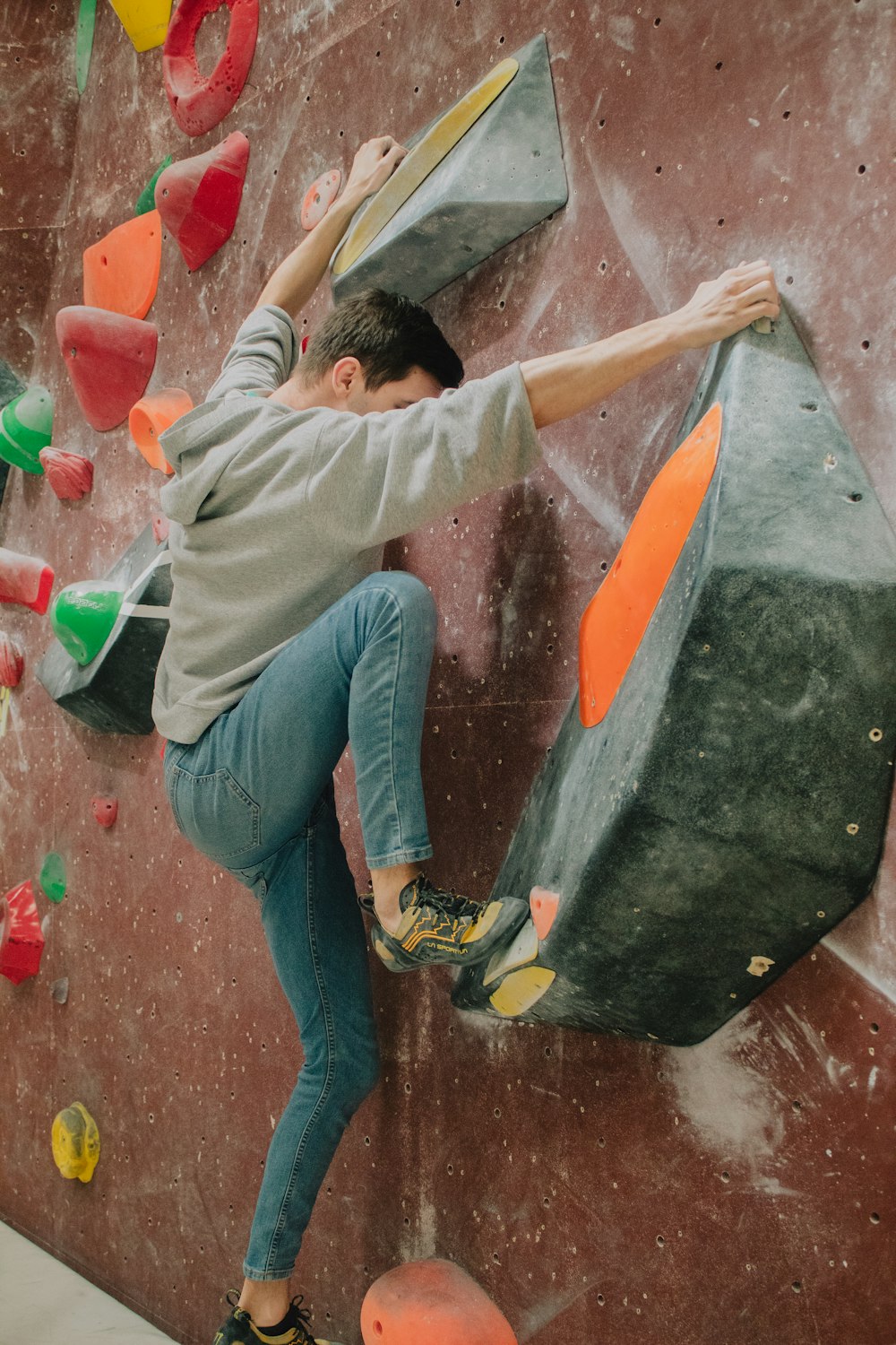 a man climbing up the side of a climbing wall