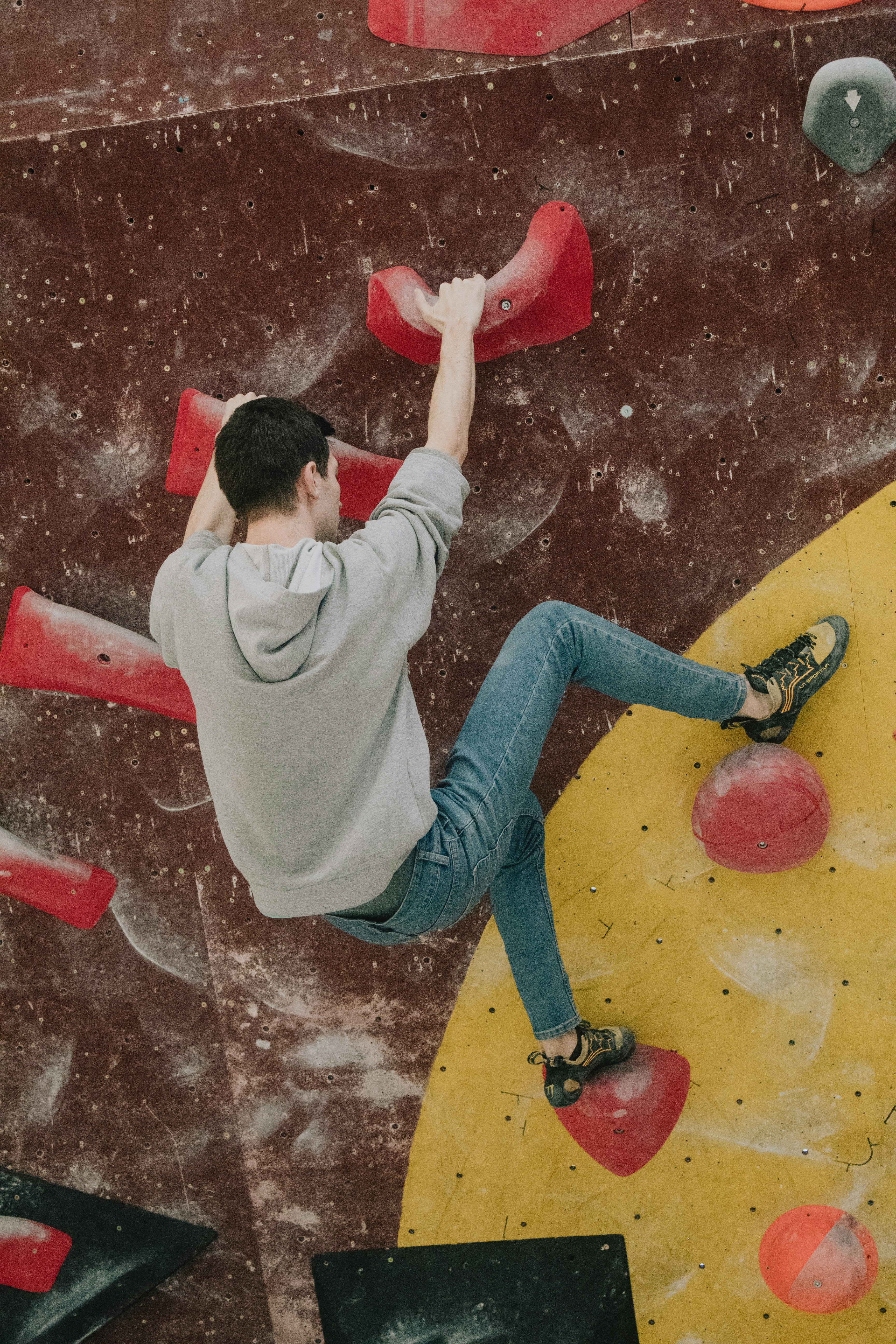 Un uomo che si arrampica sul fianco di una parete da arrampicata