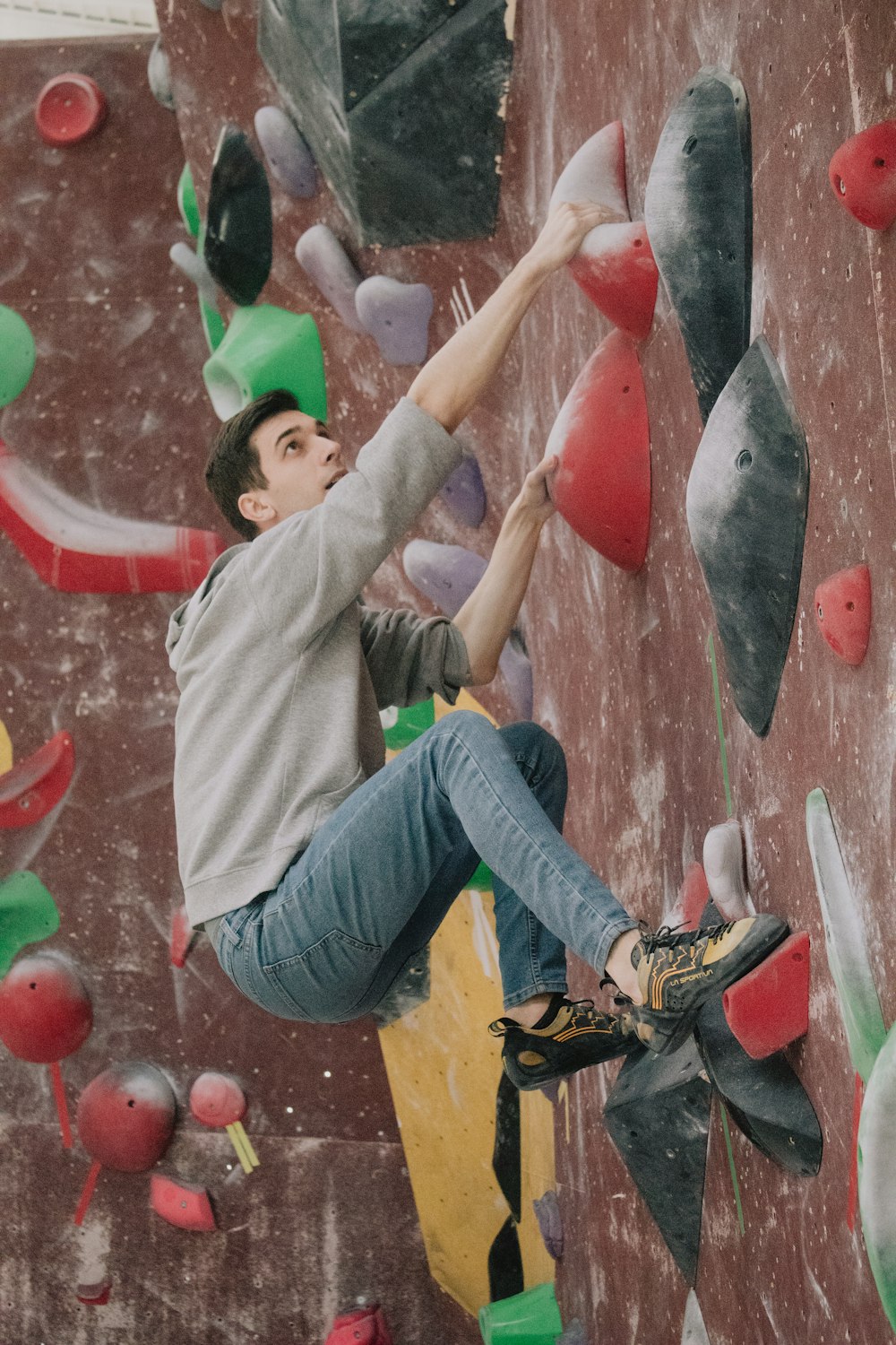 a man climbing up the side of a climbing wall