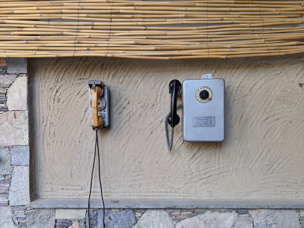 two old fashioned telephones are attached to a wall