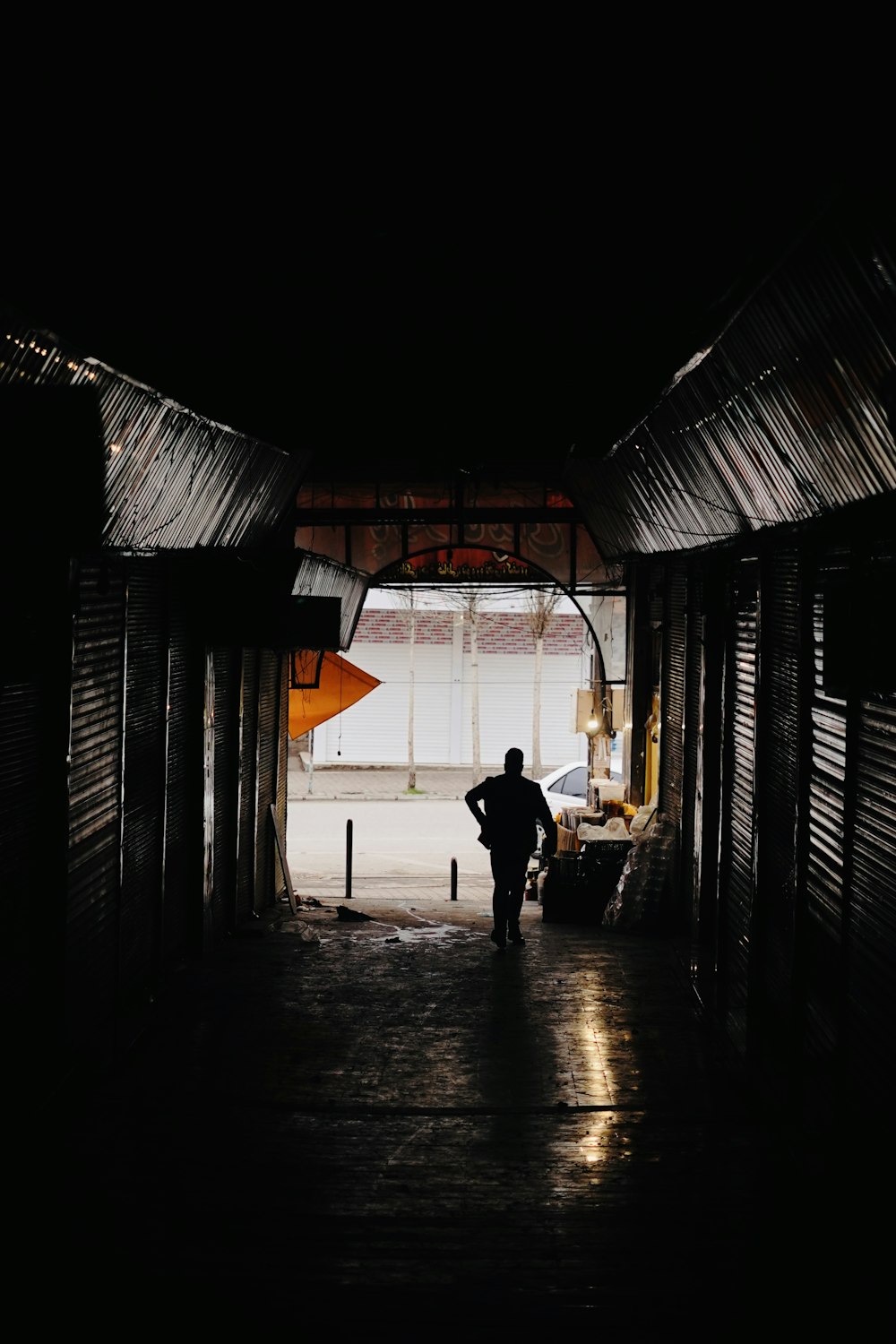 a person standing in a dark tunnel with a surfboard