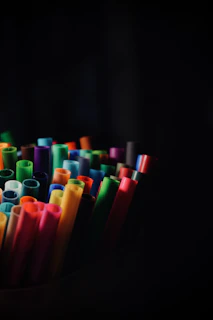 A collection of fluorescent pens arranged neatly beside a glowing LED board, ready for creative use